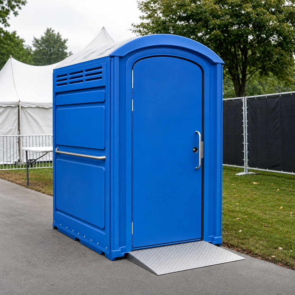 Wheelchair accessible ADA portable toilet with wide ground level entry positioned beside a paved festival pathway